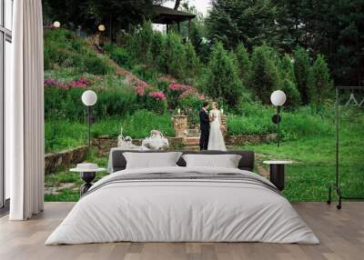 a wedding couple standing downstairs in a green area Wall mural