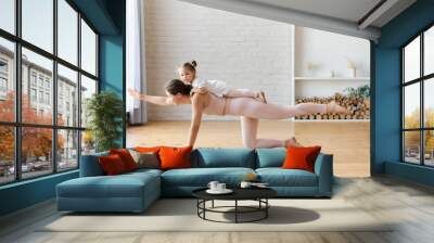 Woman in light pink outfitt practice yoga, staying in plank Side view of slender woman doing yoga Wall mural