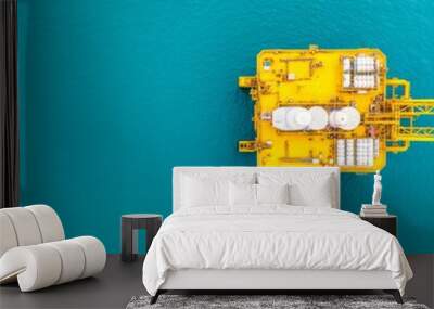 Aerial view of a yellow offshore oil platform in turquoise waters. Wall mural