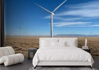 Wind turbines stand in a vast desert landscape under a clear blue sky. Wall mural