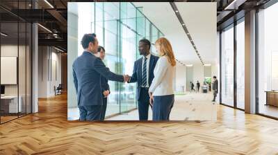 Group of multinational business people shaking hands in a lobby Wall mural