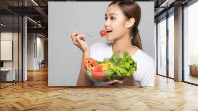 Young woman eating a salad. Wall mural