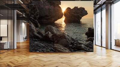 sun among the rocks on a rocky wild beach on the Mediterranean sea Wall mural