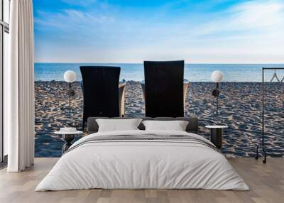 two chairs standing next to each other on the seashore in the sand. rest together Wall mural