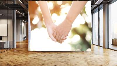 Couple lovers romantic holding hands towards with bright sun flare in public parks, or close up view in a conceptual image first love adolescent young relationship. lover Wall mural