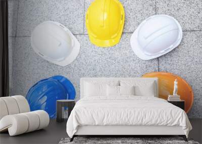 orange, yellow, blue, white hard safety wear helmet hat in the project at construction site building on concrete floor on city. helmet for workman as engineer or worker. concept safety first. top view Wall mural