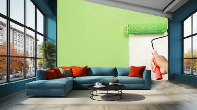 Roller Brush Painting, Worker painting on surface wall  Painting apartment, renovating with green color  paint. Leave empty copy space white to write descriptive text beside. Wall mural