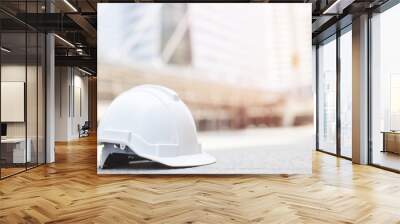 white hard safety wear helmet hat in the project at construction site building on concrete floor on city with sunlight. helmet for workman as engineer or worker. concept safety first.  Wall mural