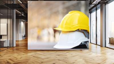 yellow and white hard safety wear helmet hat in the project at construction site building on concrete floor on city with sunlight. helmet for workman as engineer or worker. concept safety first.  Wall mural