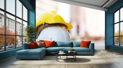 yellow and white hard safety wear helmet hat in the project at construction site building on concrete floor on city with sunlight. helmet for workman as engineer or worker. concept safety first.  Wall mural