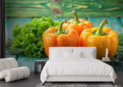 Water drops on three sweet orange peppers on green wooden background with dill and lettuce Wall mural