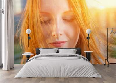 Redhead backlit by the sun closed eyes Wall mural