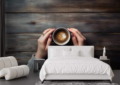 Female hands holding a cup of coffee on a wooden background, a cup of coffee, a woman holding a cup of coffee, a cup of coffee top view Wall mural