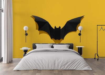 Black paper bat on a yellow background. Close-up. Wall mural