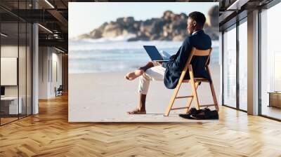 Beach, work and black man reading an email on a laptop with 5g internet while working by ocean. Relax, smile and happy African businessman doing remote business on a chair at the beach with computer Wall mural