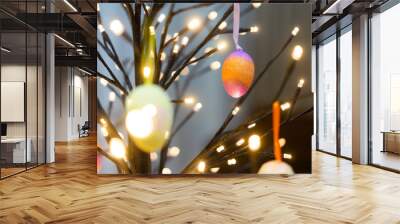 Colorful easter eggs hanging on light tree.Happy easter concept. Wall mural