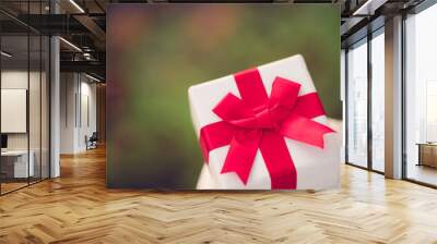 Gift box in sunset background.gift box with red bow on christmas winter celebration party season.Happy new year, Happy holidays gift box for share, donation,Christmas party surprise.Holidays party. Wall mural