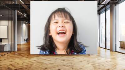 Happy Little asian girl child showing front teeth with big smile and laughing: Healthy happy funny smiling face young adorable lovely female kid.Joyful portrait of asian elementary school student. Wall mural