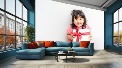 Little asian girl smile and excited and holding red gift box on white background.child holding gift box in Christmas and New year concept. Wall mural