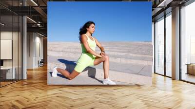 A close-up view of a young mixed race woman warming up in front of stairs outdoors  Wall mural