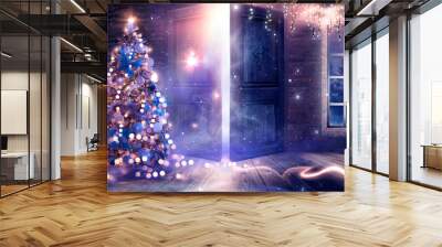 New Year tree with toys in the interior, open doors, magic light, old brick wall. Festive fabulous interior with garlands and lights. background for postcards.  Wall mural