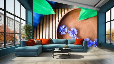 Wooden table, bowl with water tropical leaves. Flowers in the water. Tropical spa background. Reflection in the water of sunlight. Wall mural