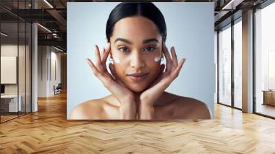 Hands, face cream and woman skincare in studio for dermatology, wellness or anti aging on grey background. Portrait, sunscreen and lady model relax with collagen, mask and lotion, beauty or facial Wall mural