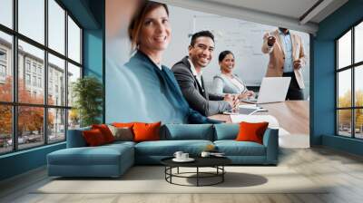 The floor is yours. Cropped shot of a handsome young businessman sitting at the boardroom table during a meeting with his colleagues. Wall mural