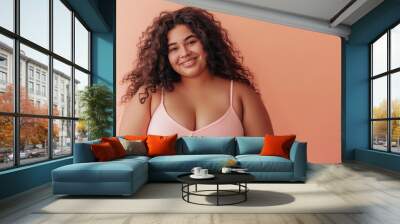 beautiful, plus size Latina woman looking happy, full body view, perfect skin, studio shot, peach light color background  Wall mural