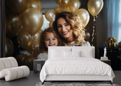 beautiful woman mother in a golden festive dress hugs her daughter on a background of balloons. Children's birthday and party concept at home Wall mural