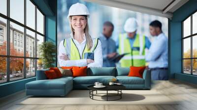 Portrait, arms crossed and a woman construction worker outdoor on a building site with her team in the background. Management, leadership and confidence with a female architect standing outside Wall mural