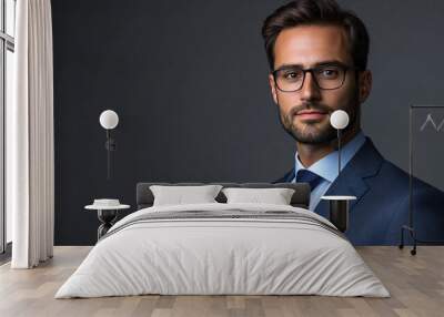 Confident businessman in a suit and glasses poses for a studio portrait against a grey background Wall mural