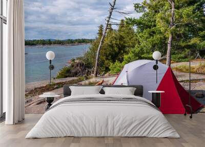  camping on georgian bay: a grey and red free standing two person tent and a fold away camping chair set up on granite with trees and lake huron in the background shot in fall Wall mural