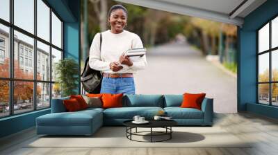 My future is calling and I must go. a young woman carrying her schoolbooks outside at college. Wall mural