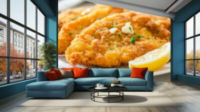 Delicious breaded chicken fillet with fresh herbs and lemon on a white plate, traditional ukrainian dish Wall mural