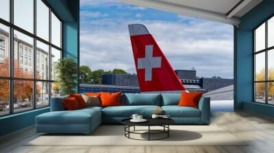 Close-up of Swiss flag at tail of passenger airplane at 75 year anniversary of Swiss Zürich Kloten Airport on a sunny summer day. Photo taken September 1st, 2023, Kloten, Canton Zürich, Switzerland. Wall mural