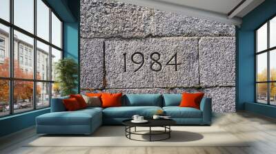 Stone wall of bridge foundation with year 1984 engraved. Photo taken June 13th, 2021, Zurich, Switzerland. Wall mural