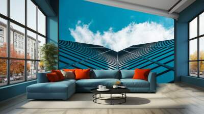 Dramatic perspective on high-rise skyscraper office building with cloudy blue sky Wall mural