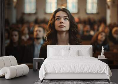 Female entrepreneur is seen praying in a church surrounded by a hopeful crowd Wall mural