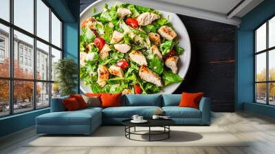 Grilled chicken breast salad with fresh lettuce, tomatoes and dressing on a dark wooden table Wall mural