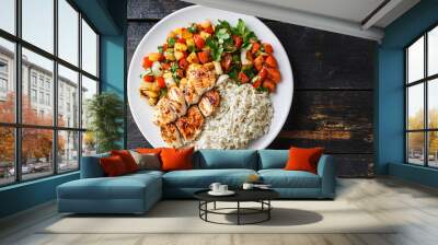 Healthy and delicious grilled chicken breast, white rice, and sauteed vegetables on a white plate, presented on a dark wooden table Wall mural