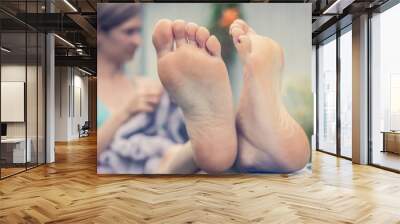 A woman is resting with her legs crossed. Female feet close-up Wall mural