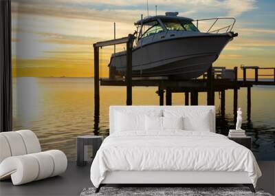 Expensive fishing boat on electric motorized dock vessel lift during sunrise with colorful sky. Wall mural