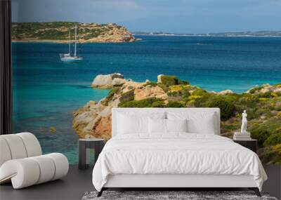 Beautiful view of the rocky shore and the boat sailing on the sea. Sardinia, Italy. Wall mural