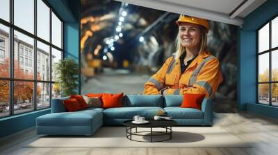 Smiling female miner standing with crossed arms in a brightly lit mine tunnel Wall mural