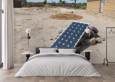 Solar panel resting on rocks in West Africa Wall mural