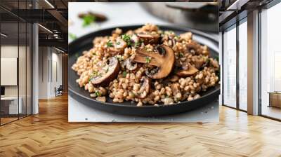 Traditional latvian barley pilaf with savory mushrooms and fresh herbs, served on a black plate to showcase baltic regional cuisine Wall mural