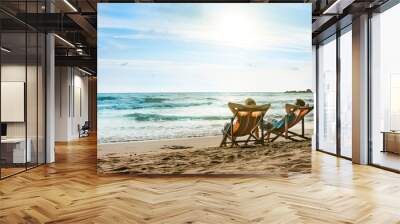 Happy couple in love sitting in deck chairs on luxury sunset sea beach in Thailand. Romantic honeymoon vacation in tropical country. Wall mural