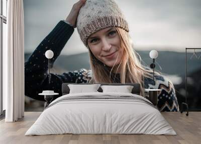 Portrait of young smiling woman wearing a handmade knitted hat Wall mural