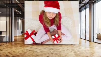 Young girl in red santa hat with gift boxes with red ribbon. Child with Christmas present, banner copy space. Top view. Wall mural